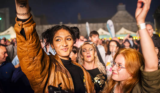 Two women dancing with their hands in the air at a live music gig in Limerick City